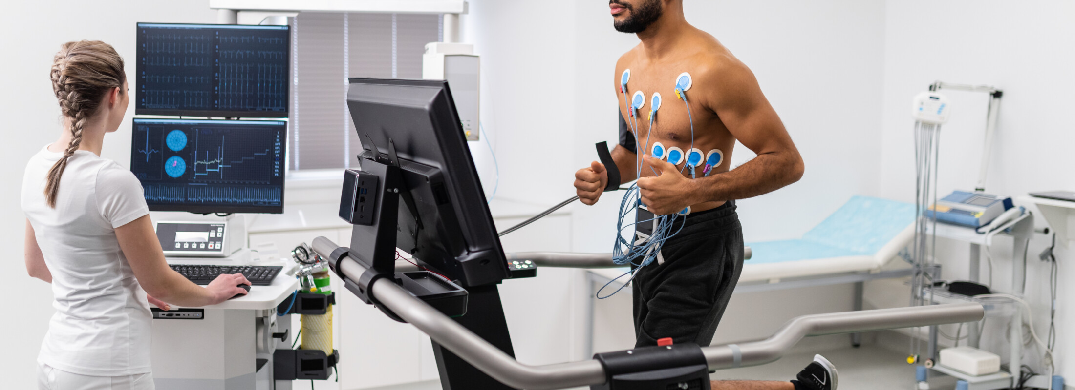 Athlete does a cardiac stress test in a medical study, monitored by the female doctor.